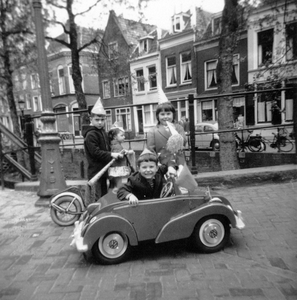845058 Afbeelding van Jan en Betty Wouda met enkele buurtkinderen met step en trapauto op de Magdalenabrug over de ...